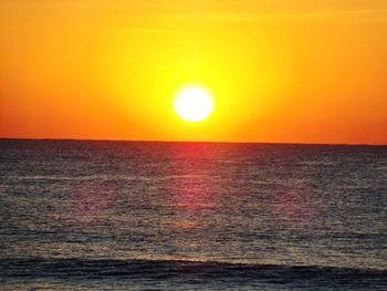 Scenic view of sea against orange sky