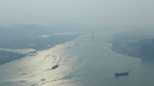 High angle view of snowcapped mountains by sea against sky