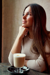 Young woman drinking coffee cup on table