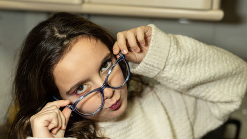 Girl grabbing the glasses by the temples and removing them from the vision of the eyes