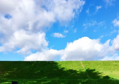 Low angle view of green landscape against sky