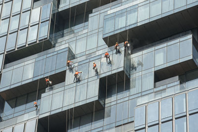 Low angle view of people working on modern building