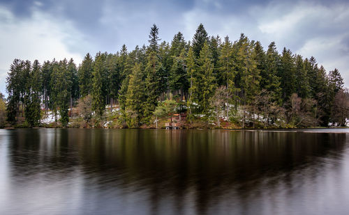 Scenic view of lake by trees against sky