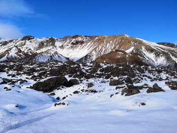 Scenic view of snowcapped mountains against clear blue sky