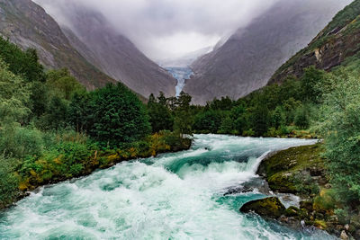 Scenic view of waterfall against sky