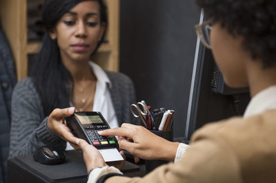 Woman doing payment at cash counter in store