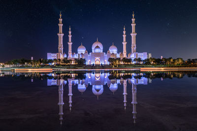 Reflection of illuminated building in lake at night