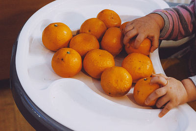 Cropped hand of person holding orange fruit