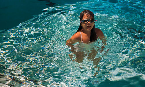 High angle view of cute girl swimming in pool