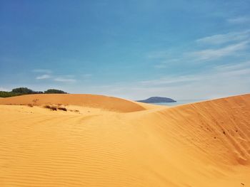 Sand dunes in desert against sky