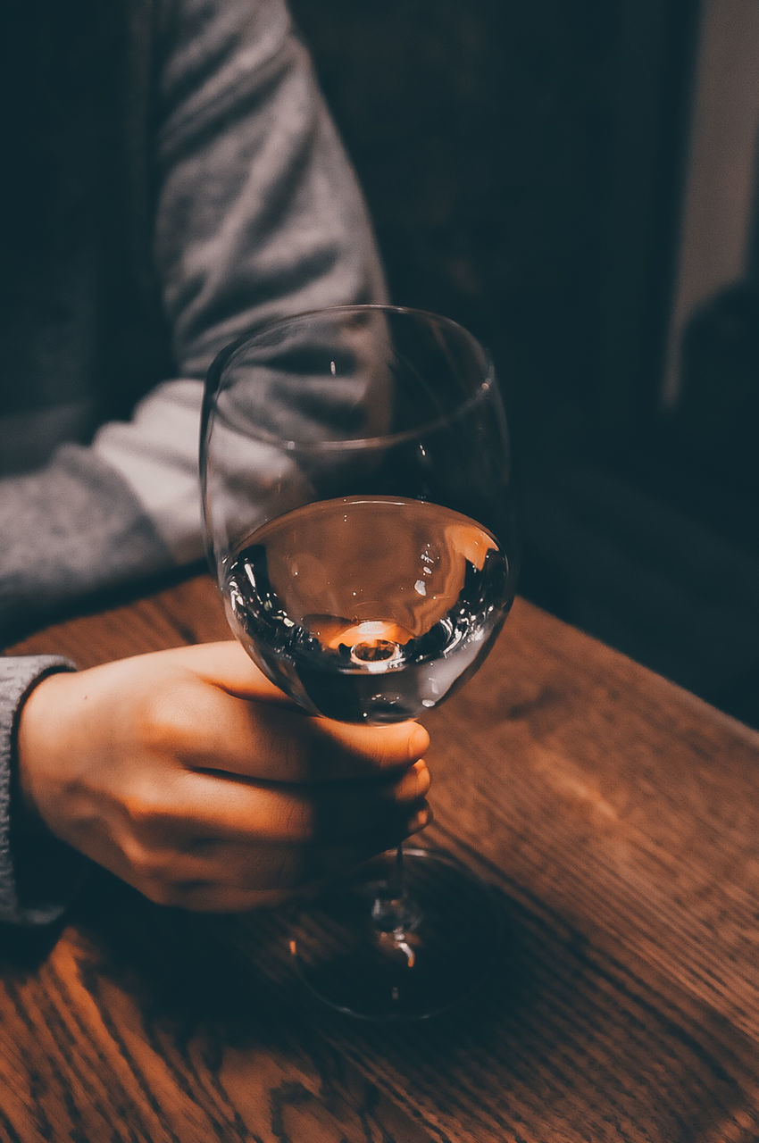 drink, refreshment, food and drink, one person, glass, real people, holding, alcohol, table, human hand, indoors, hand, human body part, lifestyles, freshness, men, drinking glass, household equipment, focus on foreground, drinking, finger