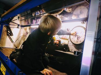 Side view of man preparing food in glass window