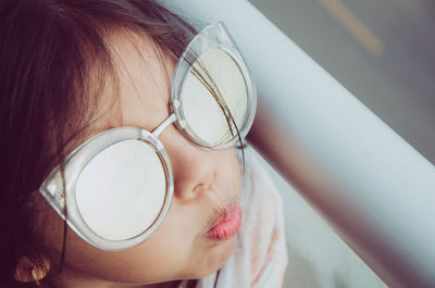 Close-up high angle view of girl wearing sunglasses on balcony