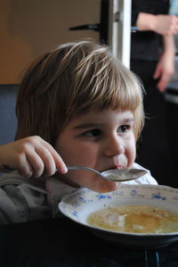 Boy eating noodle soup while sitting at home