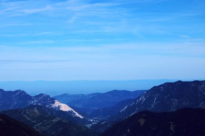 Scenic view of mountains against blue sky