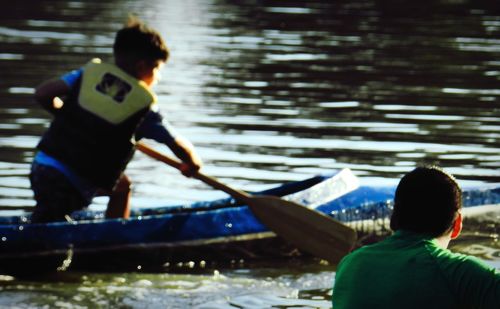 Rear view of man and boat in river