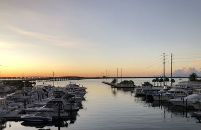 Boats in harbor at sunset