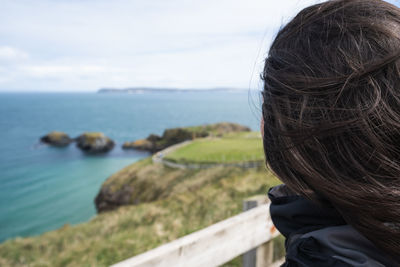 Woman looking at sea against sky