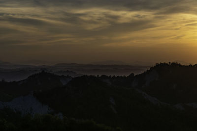 Scenic view of silhouette mountains against sky during sunset