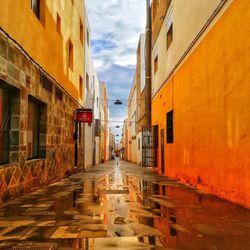 Road amidst buildings in city against sky