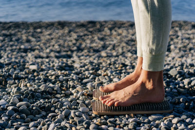 Eastern alternative medicine acupressure, barefoot woman stand on wooden planks with nails