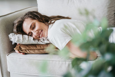 Beautiful woman lies on the sofa and smiles.