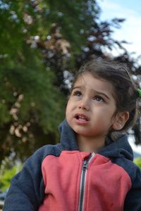 Close-up of cute baby girl looking away outdoors