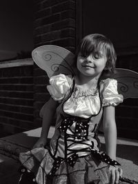 Girl wearing butterfly costume wing on seat