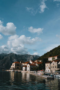 Buildings by sea against sky