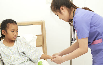 Nurse examining patient at home