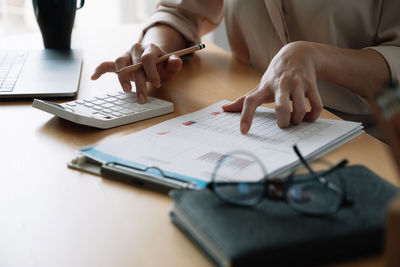 Midsection of woman working on table