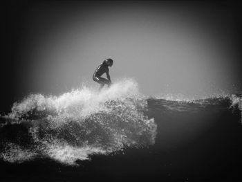 Silhouette man surfing in sea