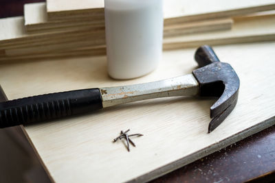 Close-up of hammer with nails on table