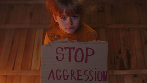 Portrait of young woman standing against text