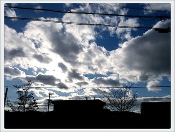 Low angle view of buildings against cloudy sky