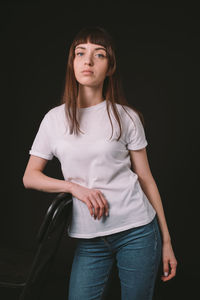 Portrait of a teenage girl against black background