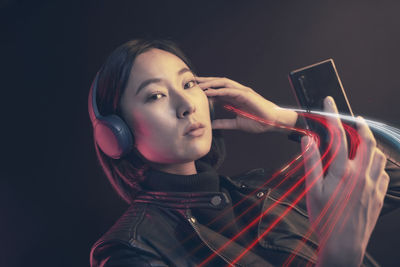 Portrait of mid adult woman against black background