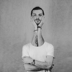 Portrait of young man standing against wall