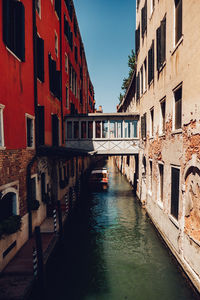 Canal amidst buildings in city against clear sky