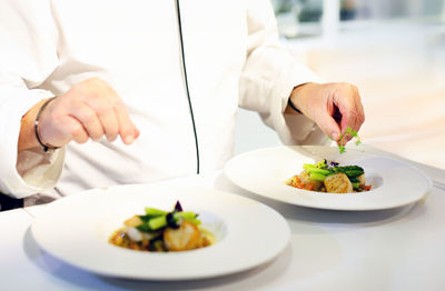 Midsection of woman having food on table