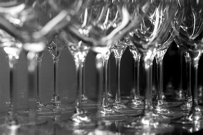 Detail in black and white of many goblets grouped in row ready to be used