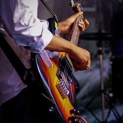 Midsection of man playing guitar