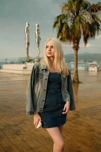 Portrait of young blonde beautiful girl with palms in batumi 