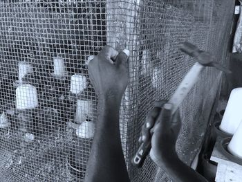 Close-up of human hand in cage