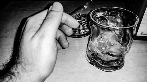 Close-up of hand holding beer glass on table