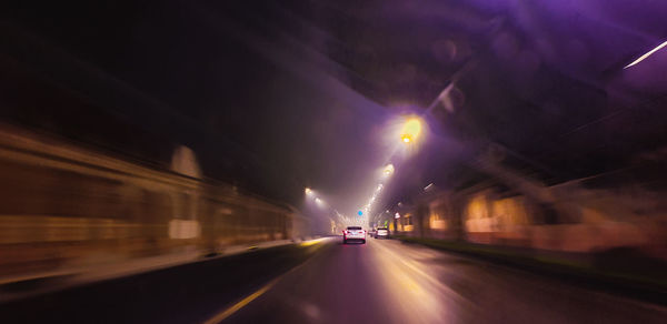 Cars on road in illuminated tunnel