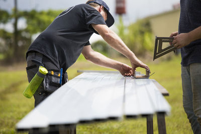 Man holding umbrella while standing on table