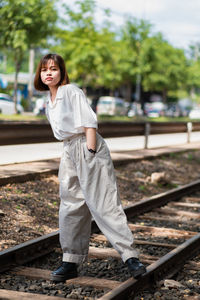 Young woman standing on railroad track