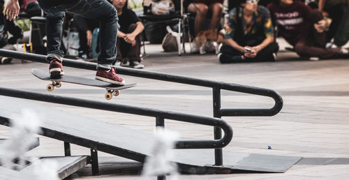 Low section of man skateboarding on railing