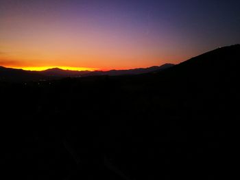 Silhouette landscape against sky during sunset